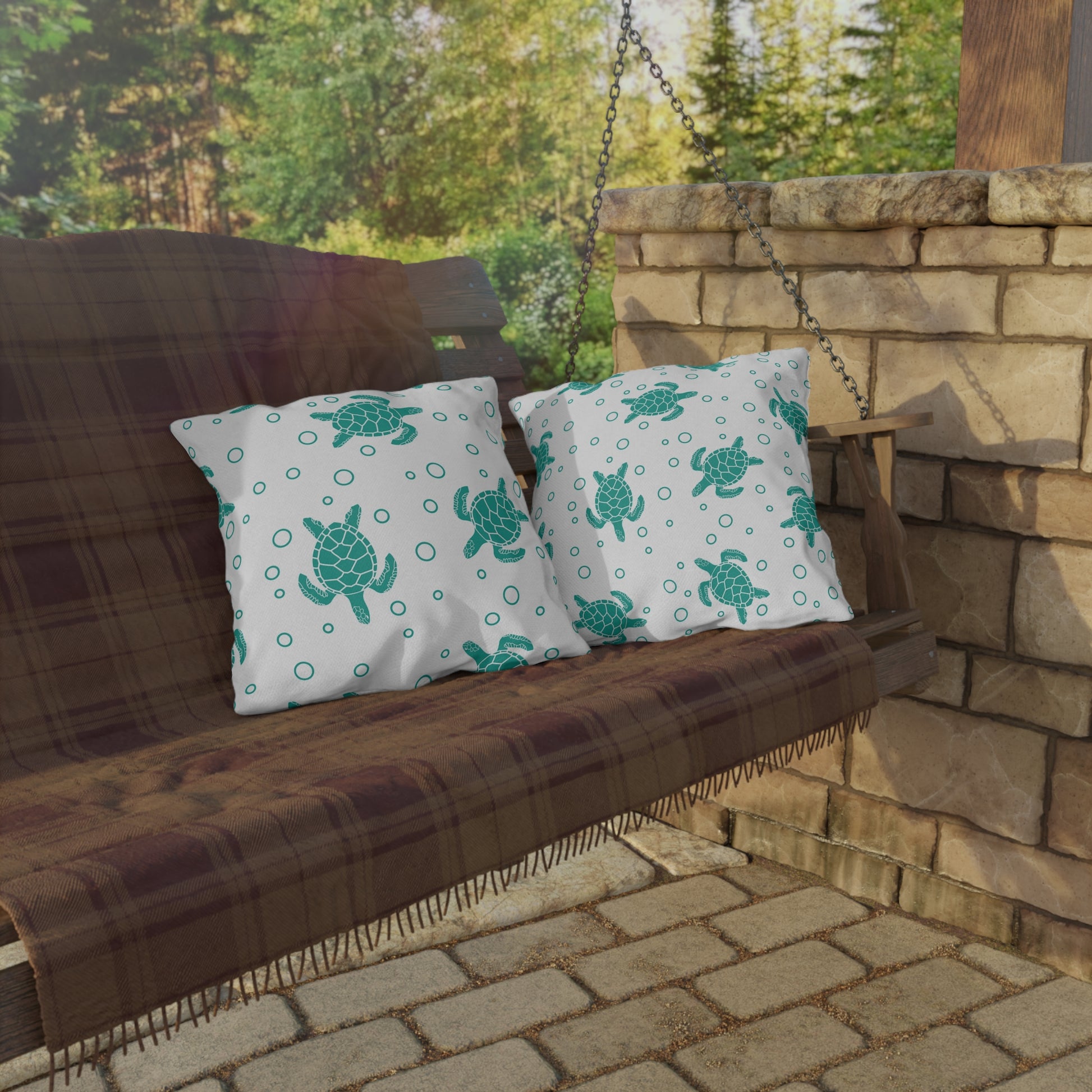 Pair of outdoor sea turtle pillows with teal turtles and dotted circle pattern
