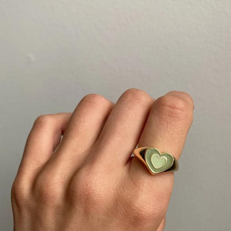 Heart-shaped ring, gold-tone band with green heart enamel, worn on hand