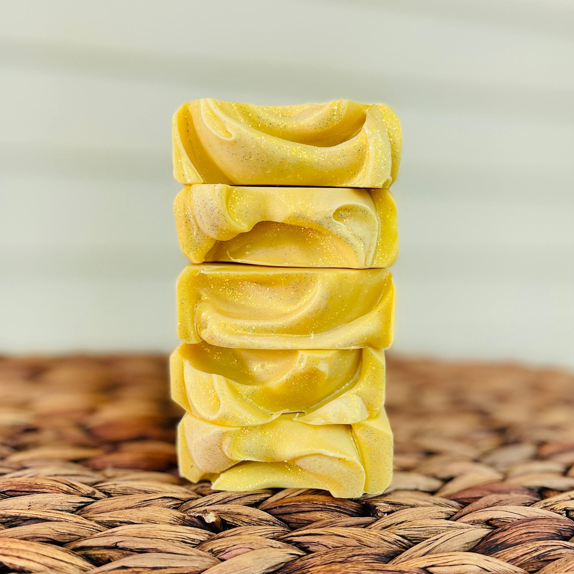 Piled yellow soap bars with speckled texture and layered edges