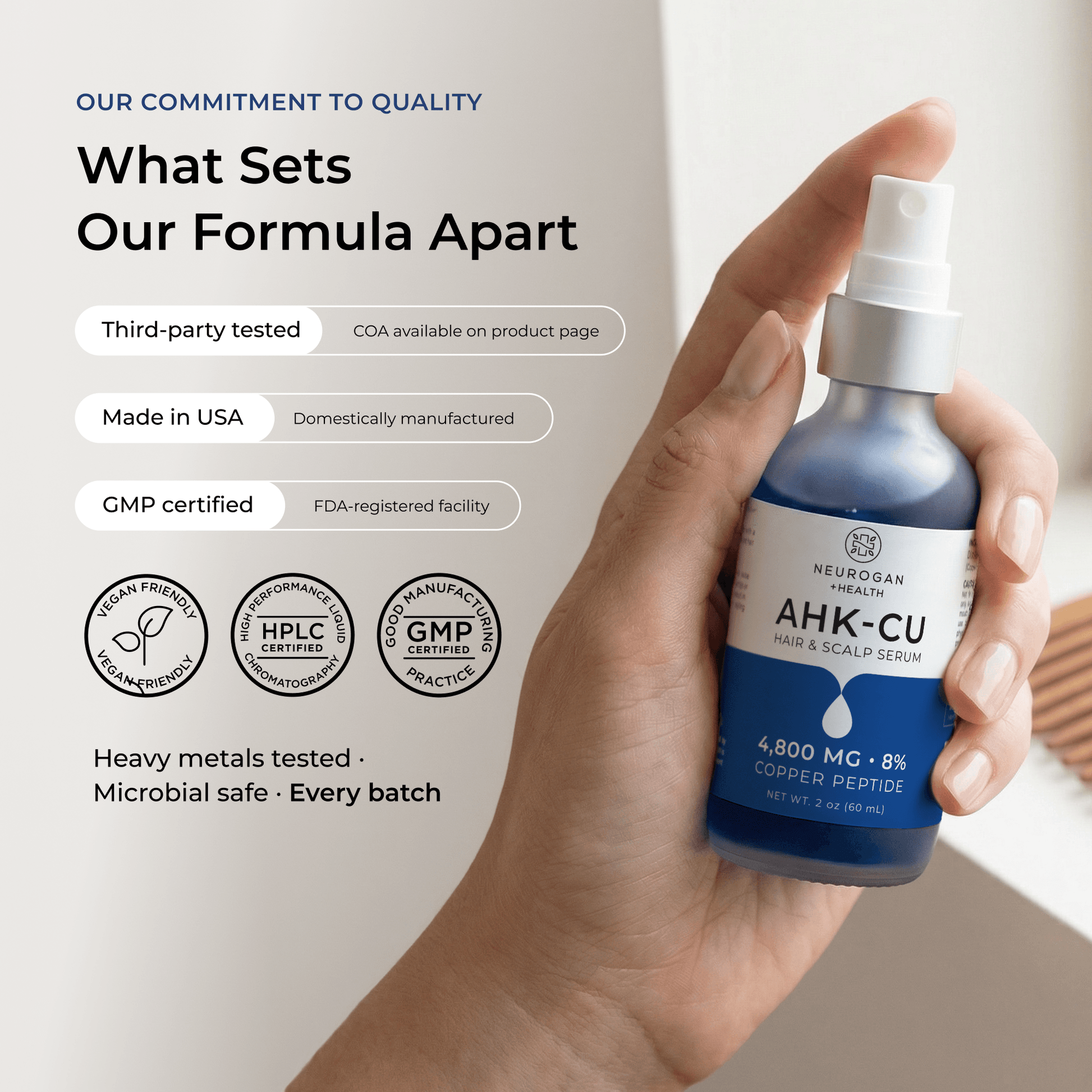AHK-Cu hair serum bottle held in hand with blue liquid and white pump sprayer.