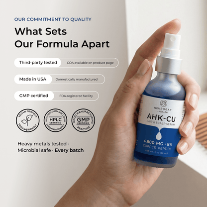 AHK-Cu hair serum bottle held in hand with blue liquid and white pump sprayer.