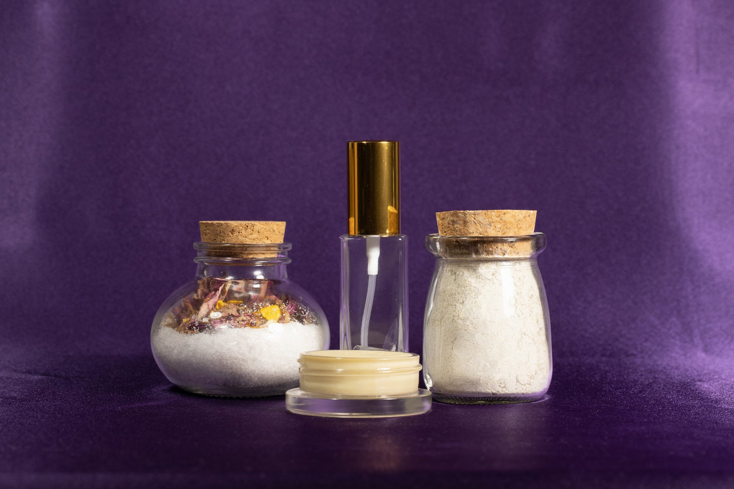 Spa gift set with two salt jars, clear spray bottle, and small cream jar in front