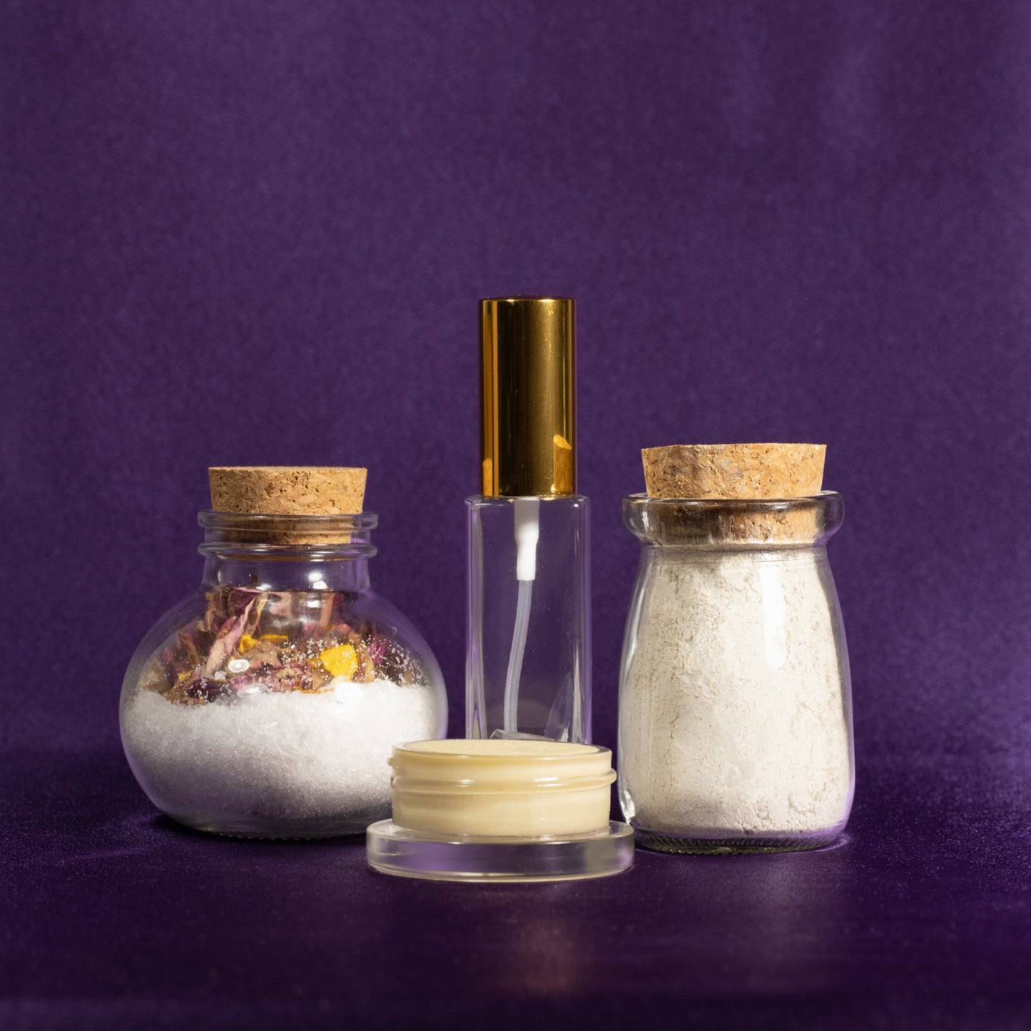 Spa gift set with glass bottles, jars of salts, and a small cream jar with lid