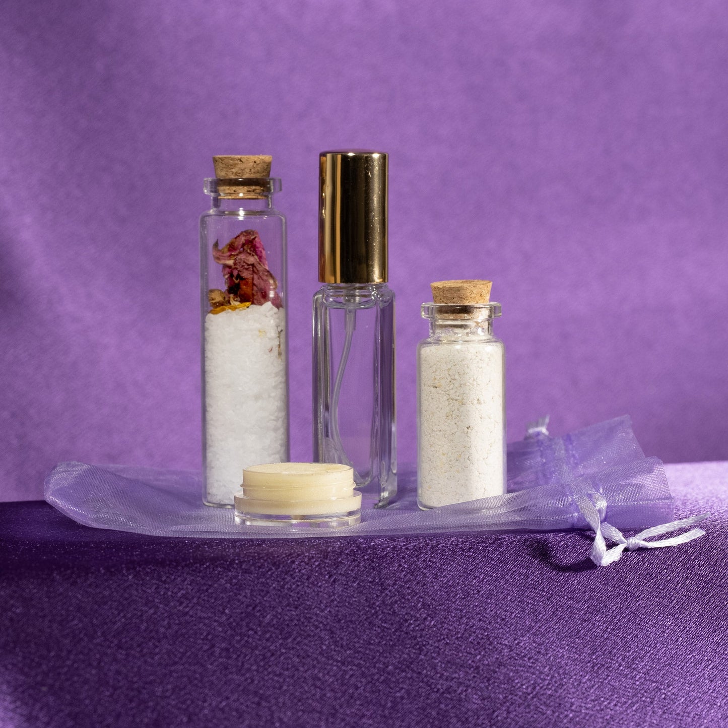 Spa gift set with glass bottles, salt jars, cream jar, and wrapped accessories