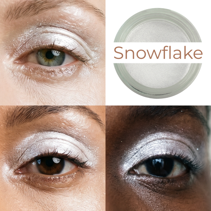 Shimmering white cream-to-powder makeup jar beside eye makeup with silvery shimmer