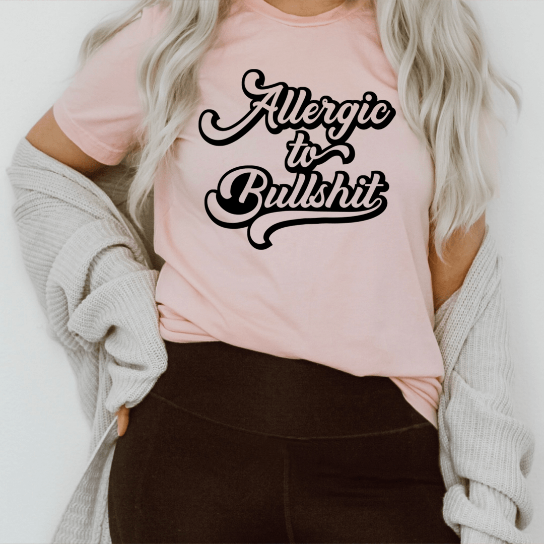 Light pink crewneck T-shirt featuring 'Allergic to Bullshit' text graphic