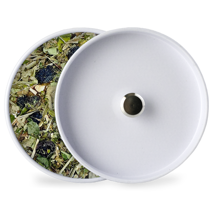White tin lid with herbal tea blend beside it
