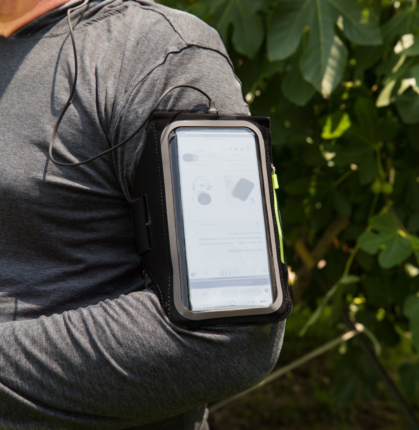 Armband phone pouch worn on arm over gray shirt with phone in clear window