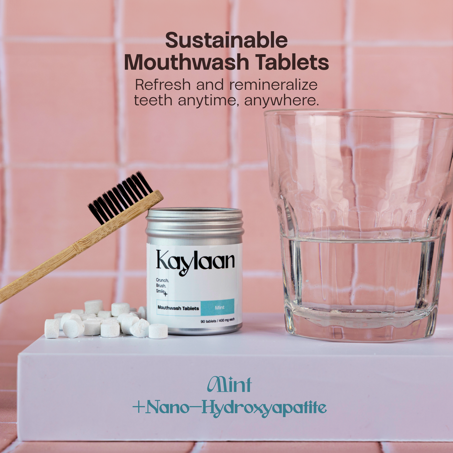Mouthwash tablets jar with mint tablets, wooden toothbrush, and glass of water
