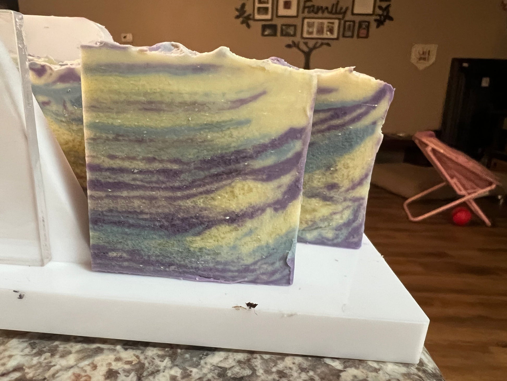 Swirled soap bars in purple, blue, and green on a white tray