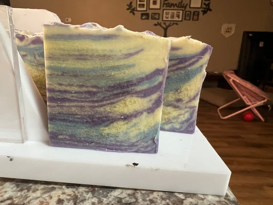 Swirled soap bars in purple, blue, and green on a white tray