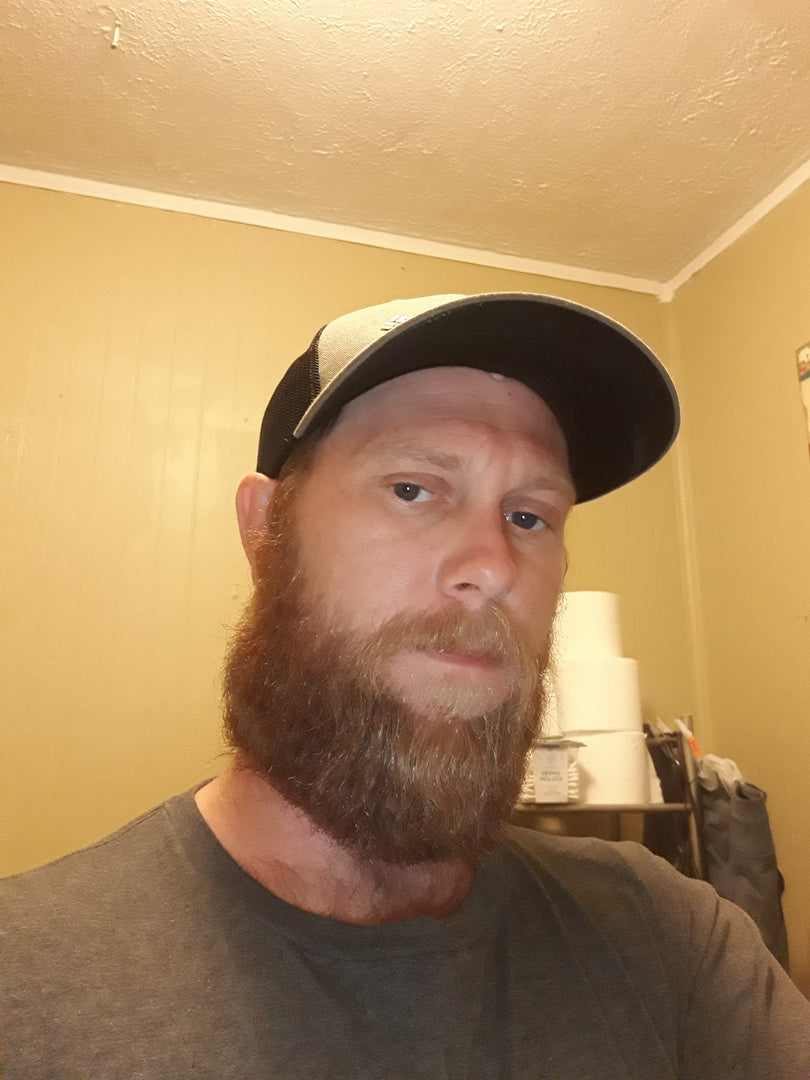 Organic beard oil; man with full beard and cap, close-up