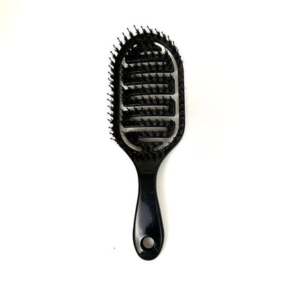 Glossy black massage hair comb with pin tips and oval thumb hole on handle