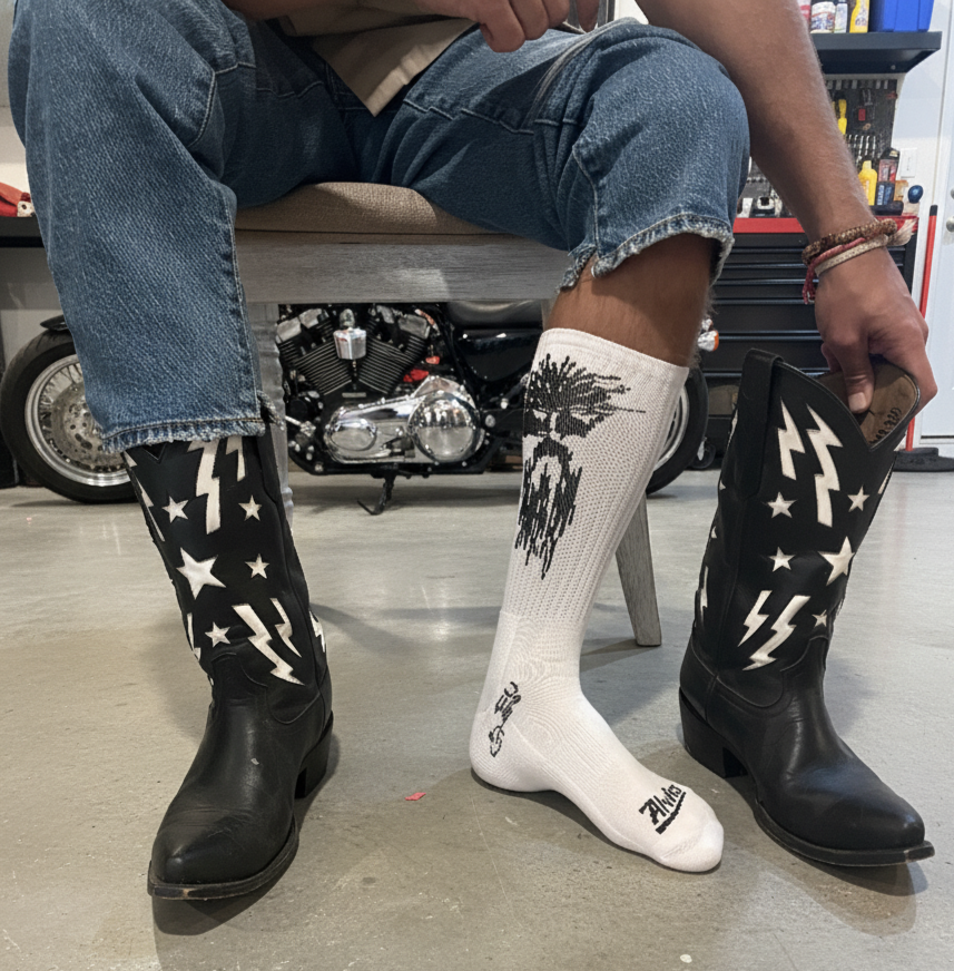 White ribbed boot socks with black tree-and-drip graphic, worn with dark boots.