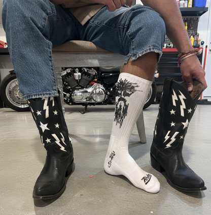 White ribbed boot socks with black tree-and-drip graphic, worn with dark boots.