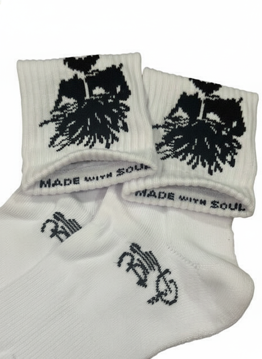 White boot socks with black tree graphic and drips, ribbed cuffs with text detail.