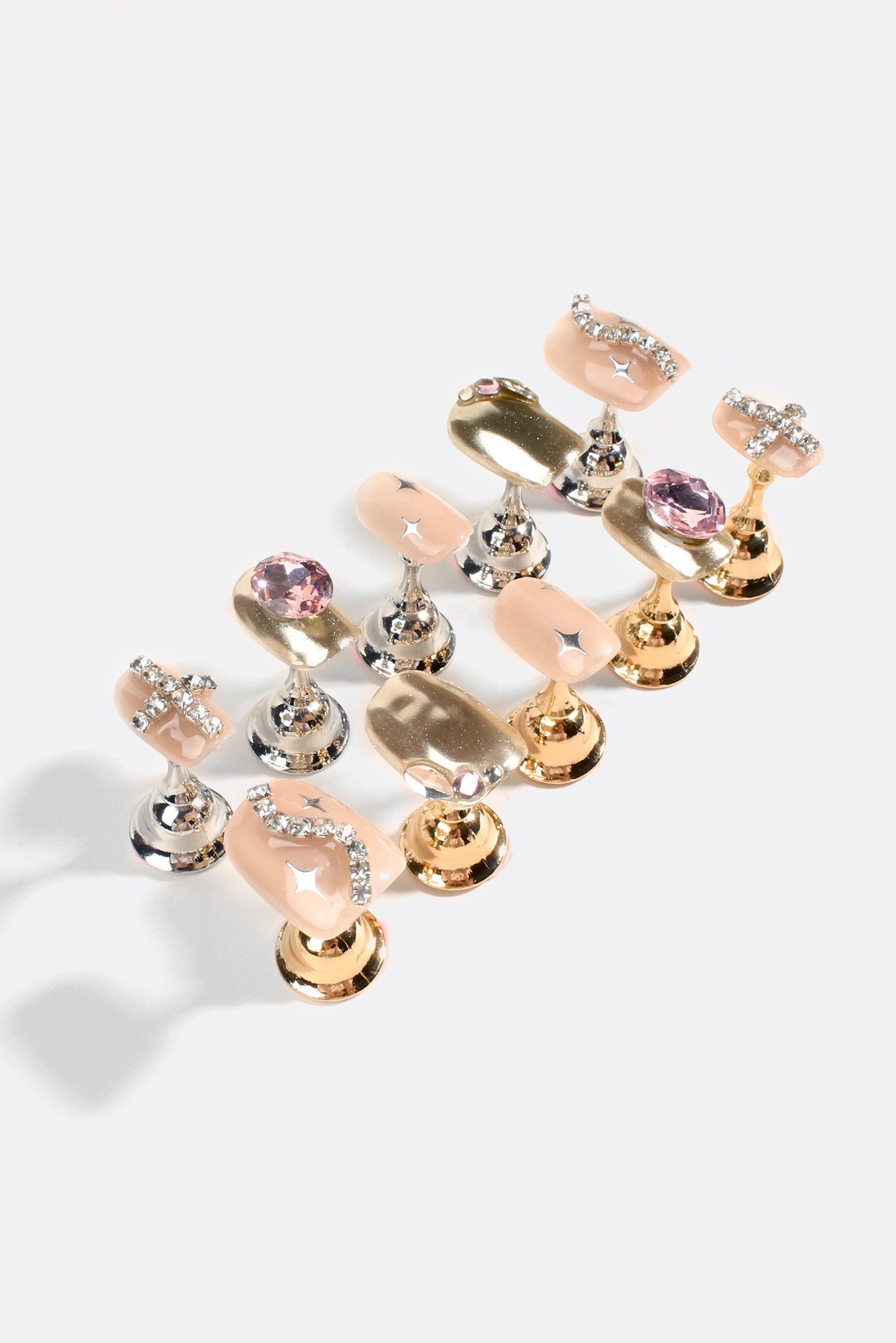 Set of gold and silver rhinestone gel nail tips with nude bases and pink stones