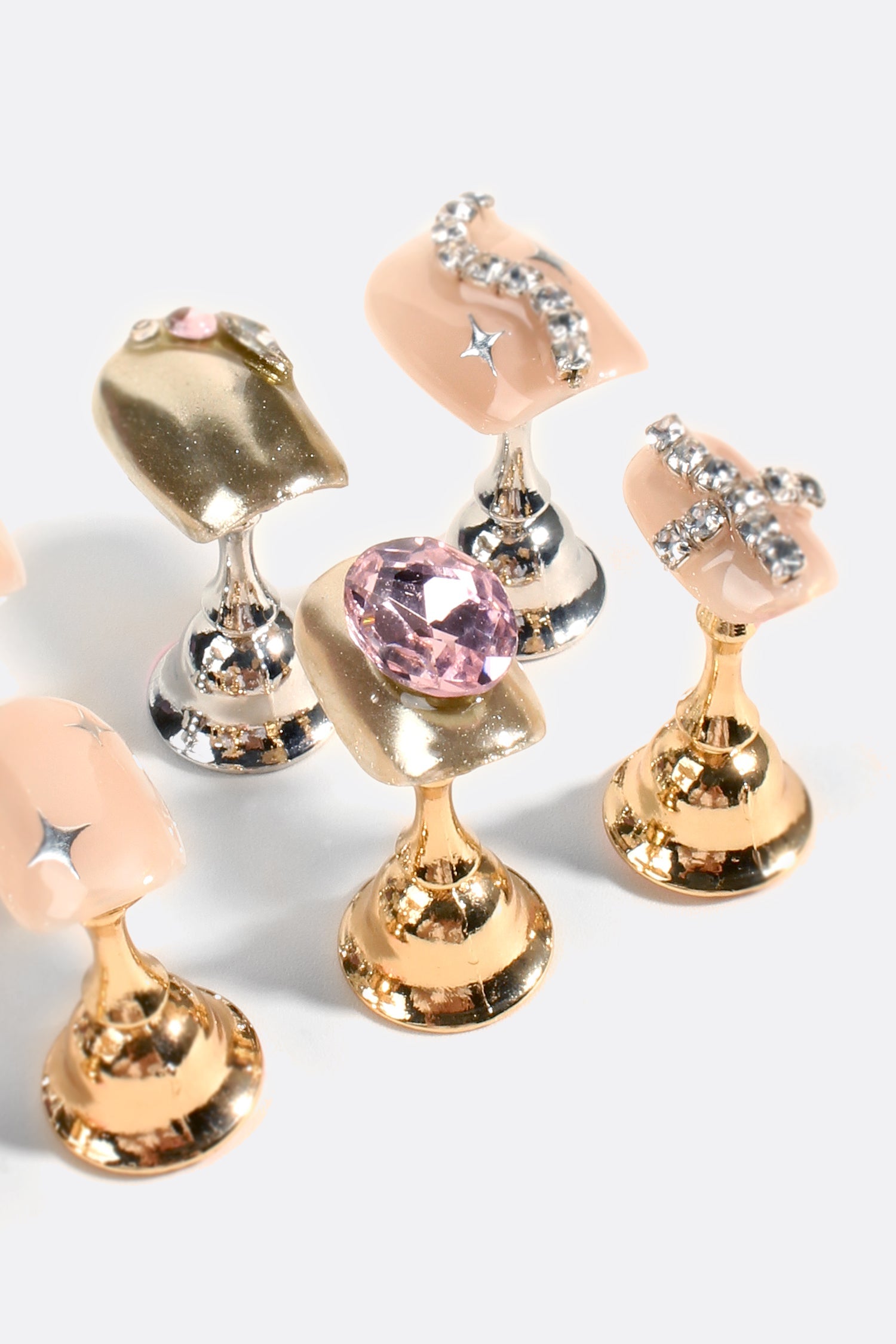 Rhinestone gel nail tips with nude panels, large pink crystal centers, gold and silver