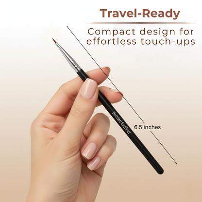 Pointed eyeliner brush held in hand; black handle, silver ferrule, tapered tip