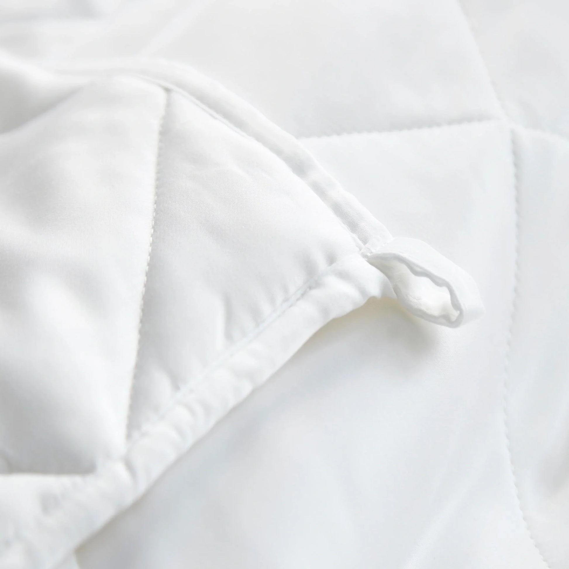 White duvet comforter corner close-up with stitched edge and inner baffling