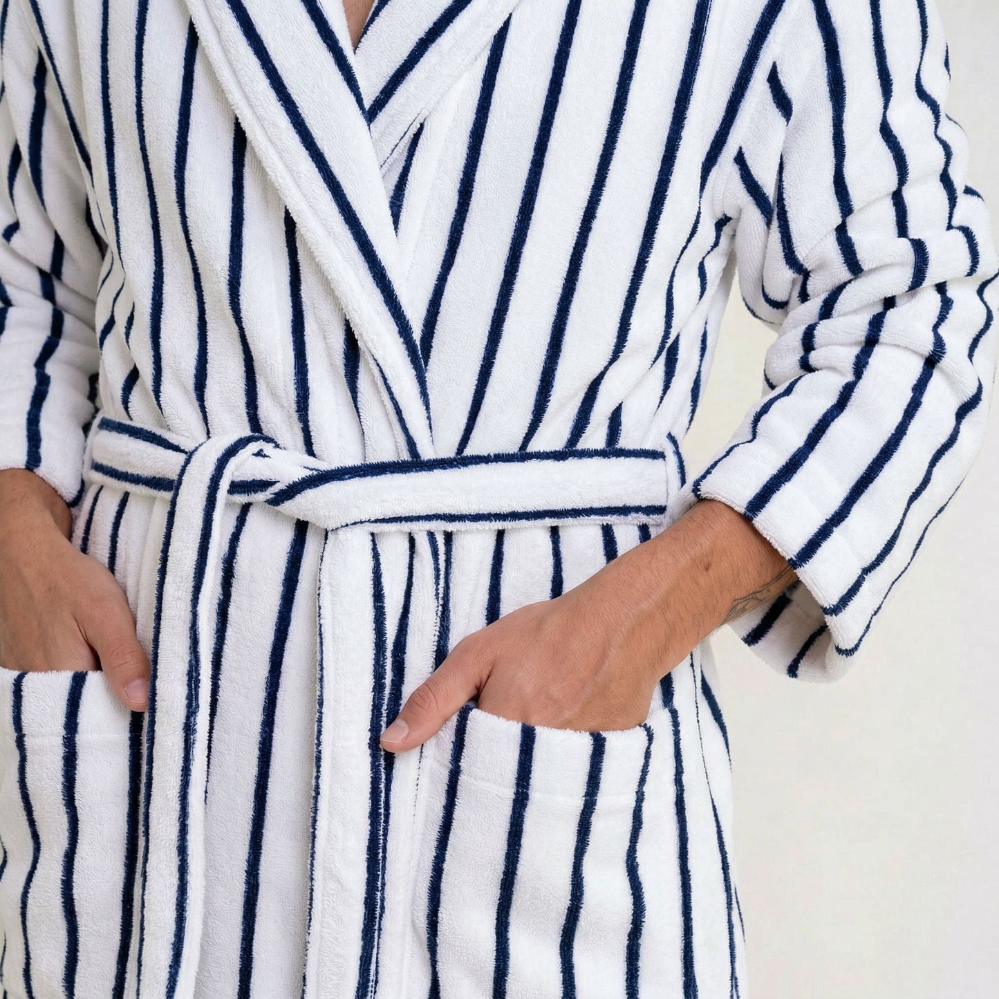 Cotton bathrobe close-up: striped fabric belt tie at waist and long sleeves; white/blue stripes
