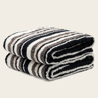 Black and cream striped cotton towels, folded stack