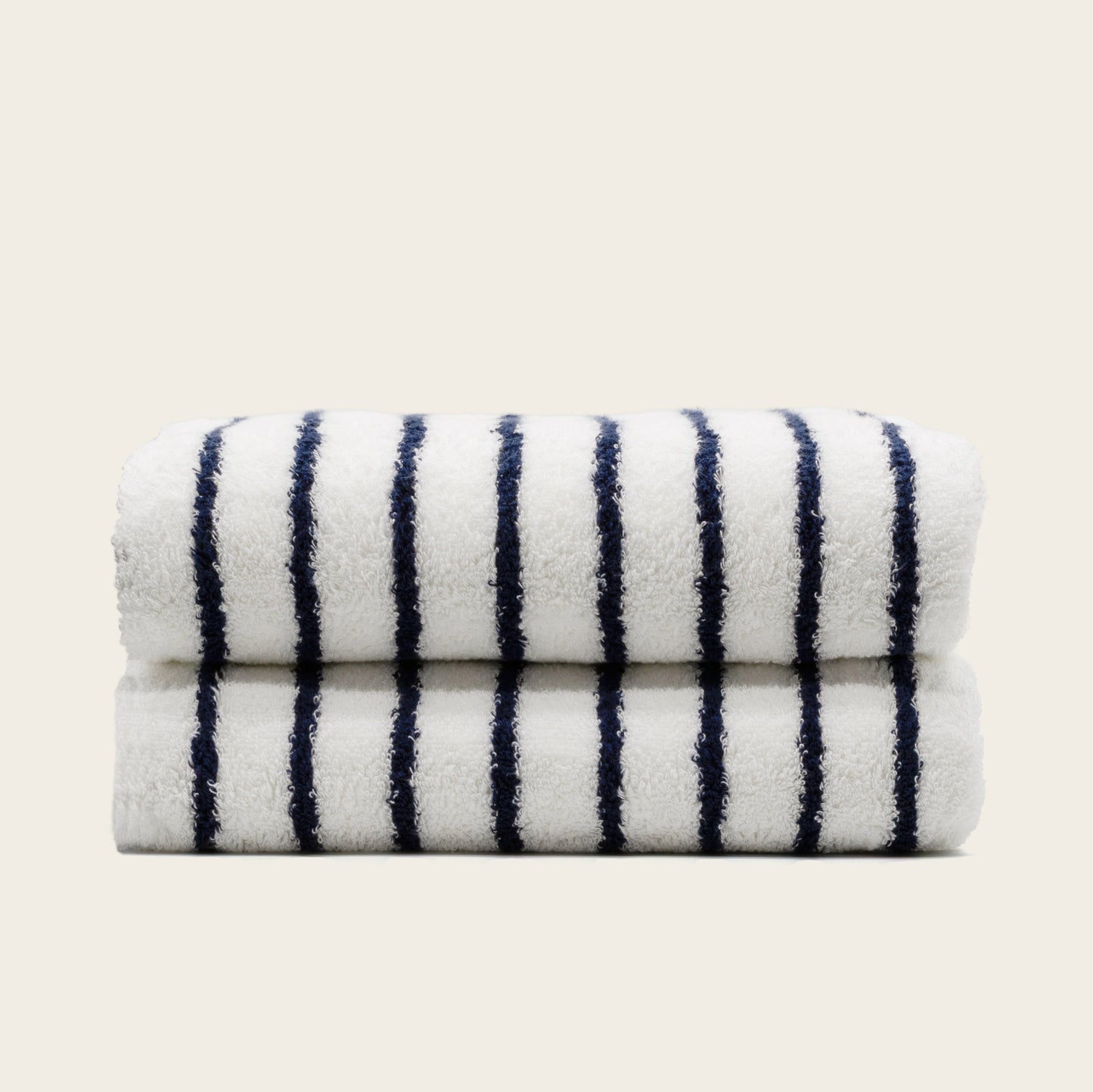Folded plush bath towel, white with navy vertical stripes.