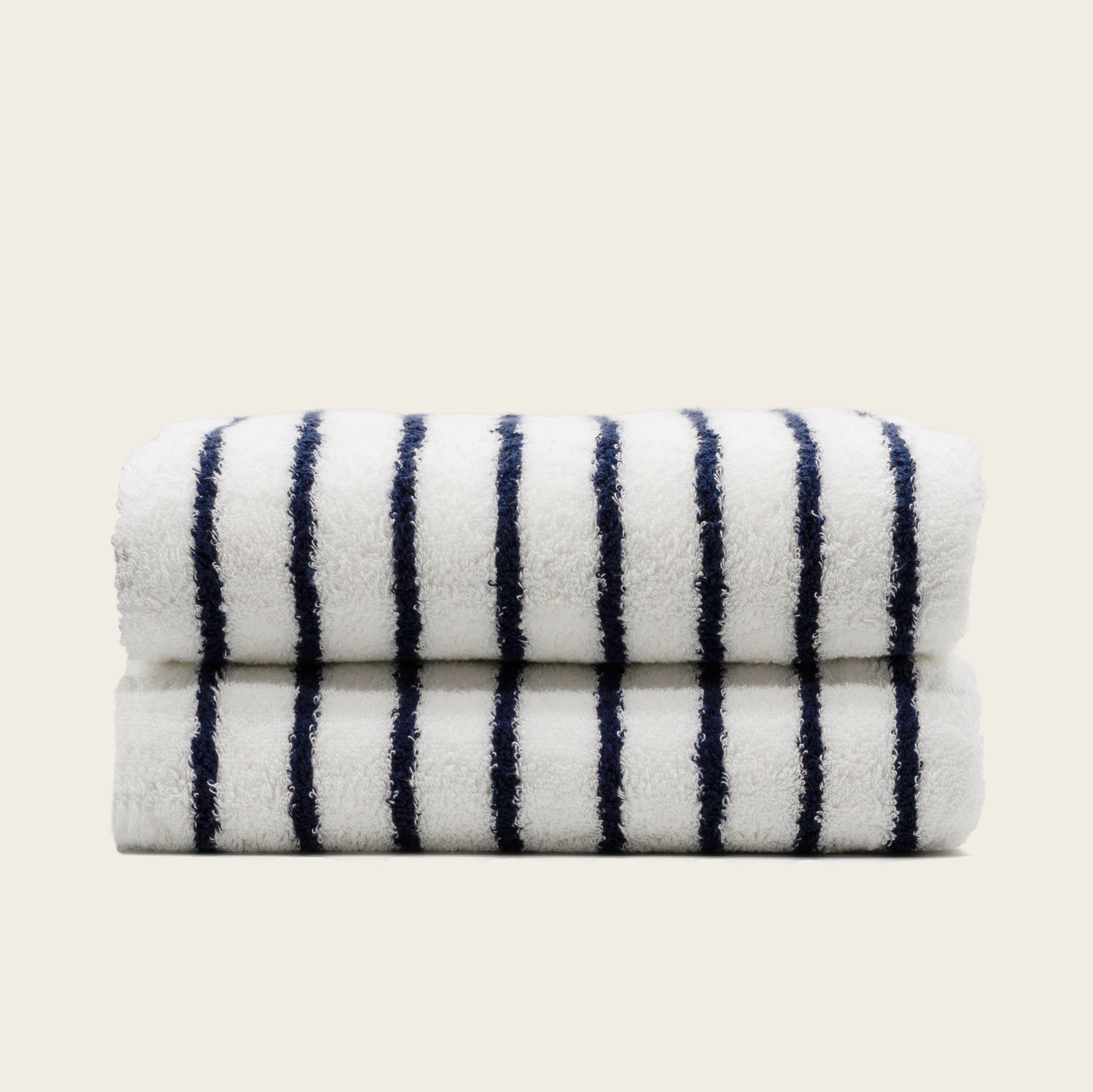 Folded plush bath towel, white with navy vertical stripes.