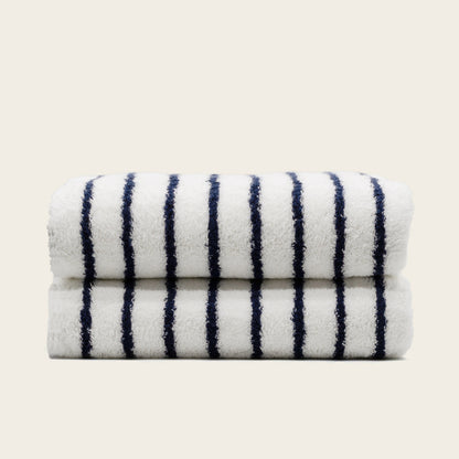 Folded plush bath towel, white with navy vertical stripes.
