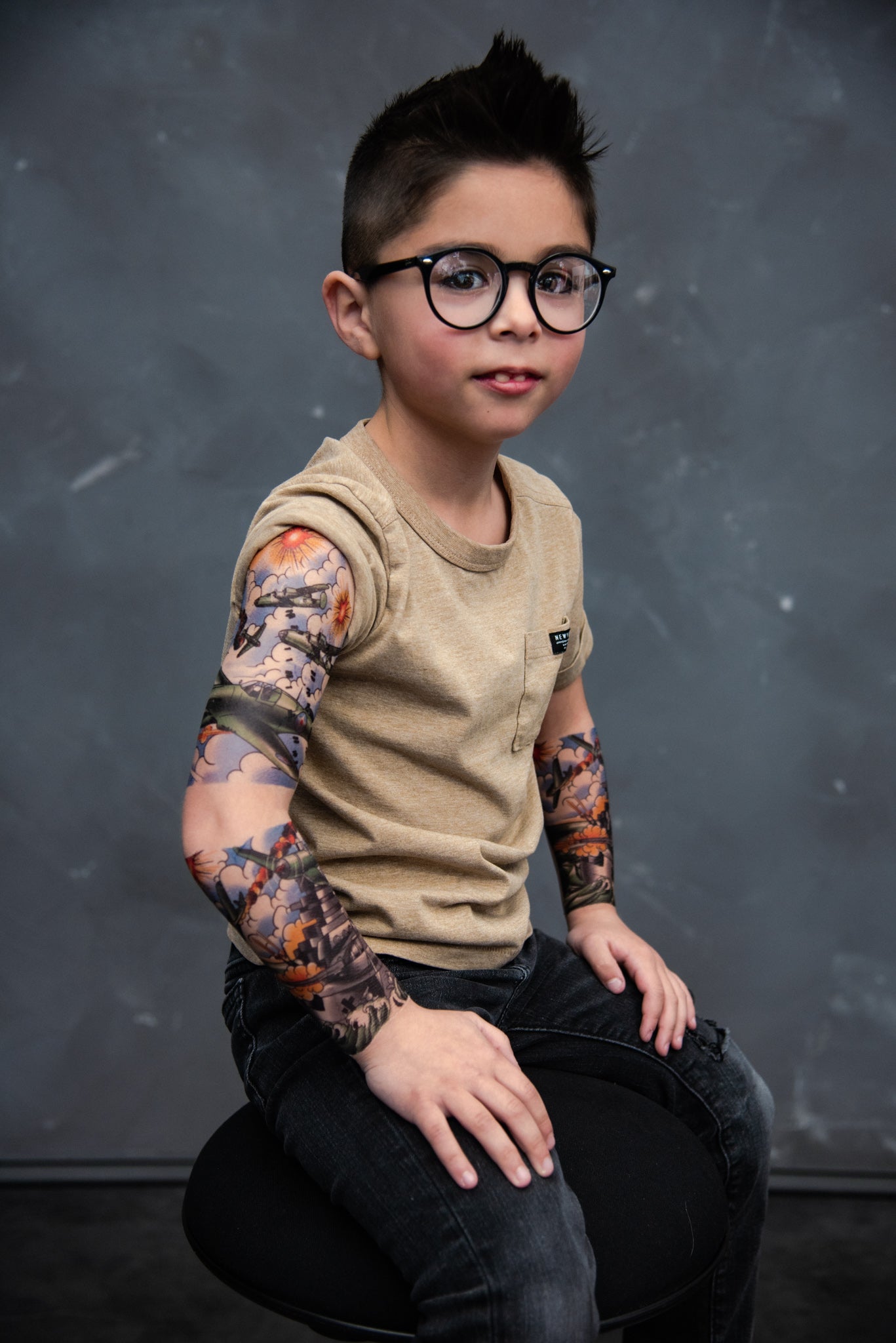 Temporary tattoo sleeve on child's arm with colorful jet and cloud artwork