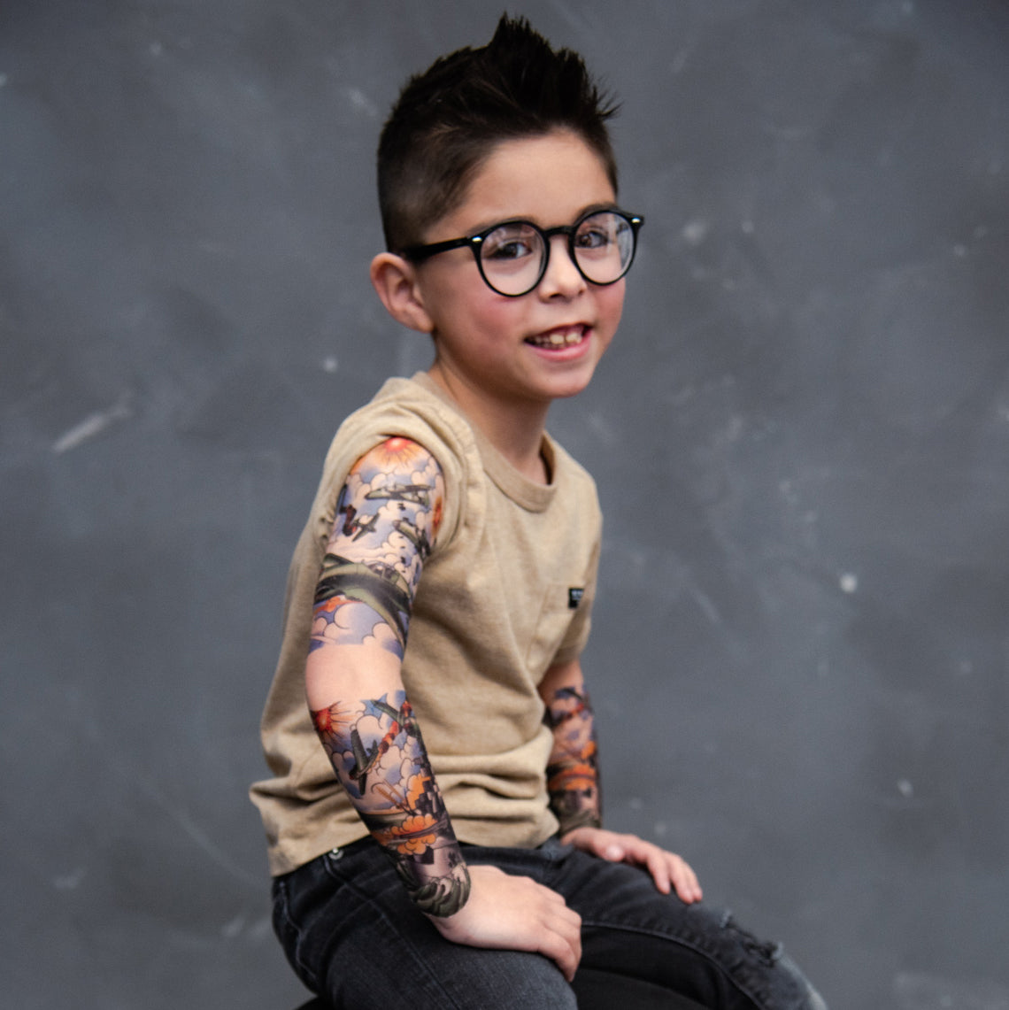 Temporary tattoo sleeve on child's upper arm, jet and cloud illustrations