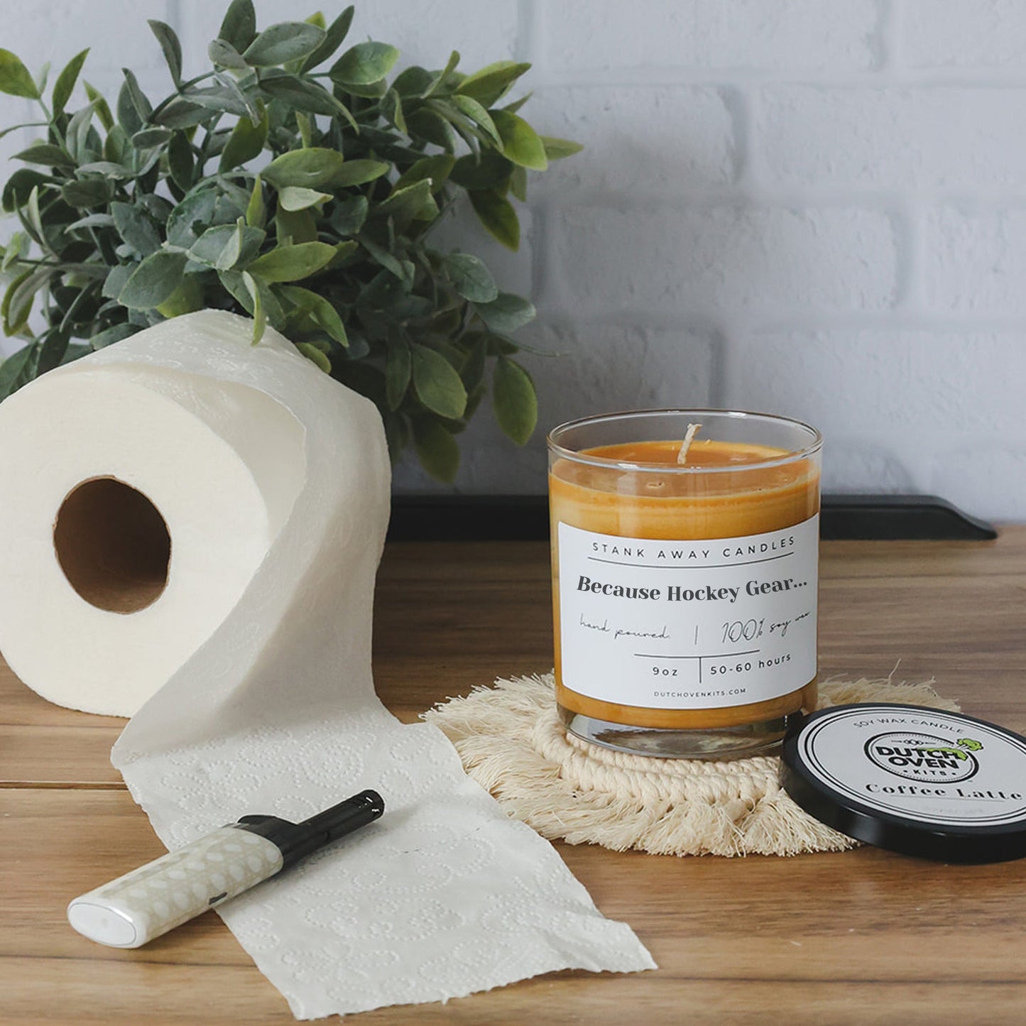 Clear glass soy wax candle with orange wax and printed "Because Hockey Gear" label