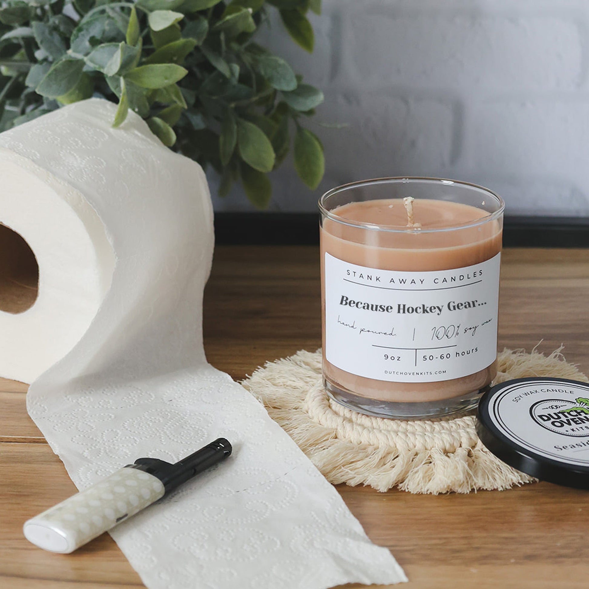 Clear glass soy wax candle with light tan wax and printed "Because Hockey Gear" label