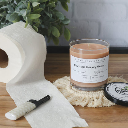 Clear glass soy wax candle with light tan wax and printed "Because Hockey Gear" label