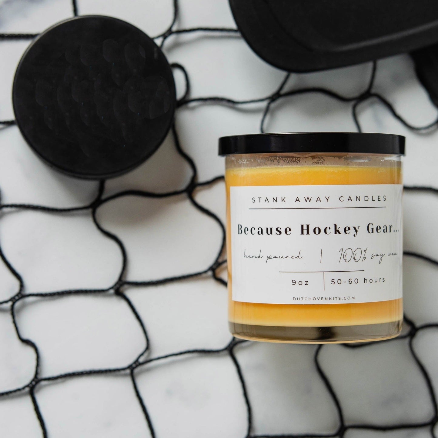 Clear glass soy wax candle with orange wax and printed "Because Hockey Gear" label
