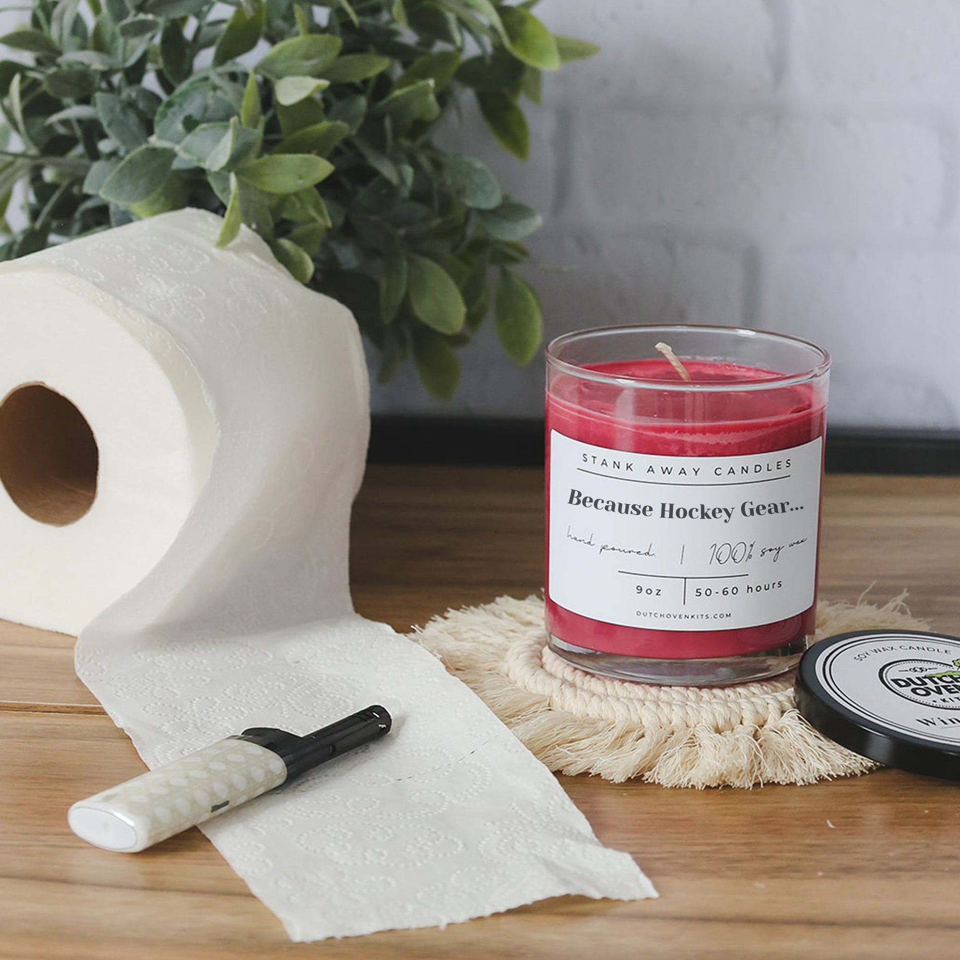 Clear glass soy wax candle with red wax and printed "Because Hockey Gear" label