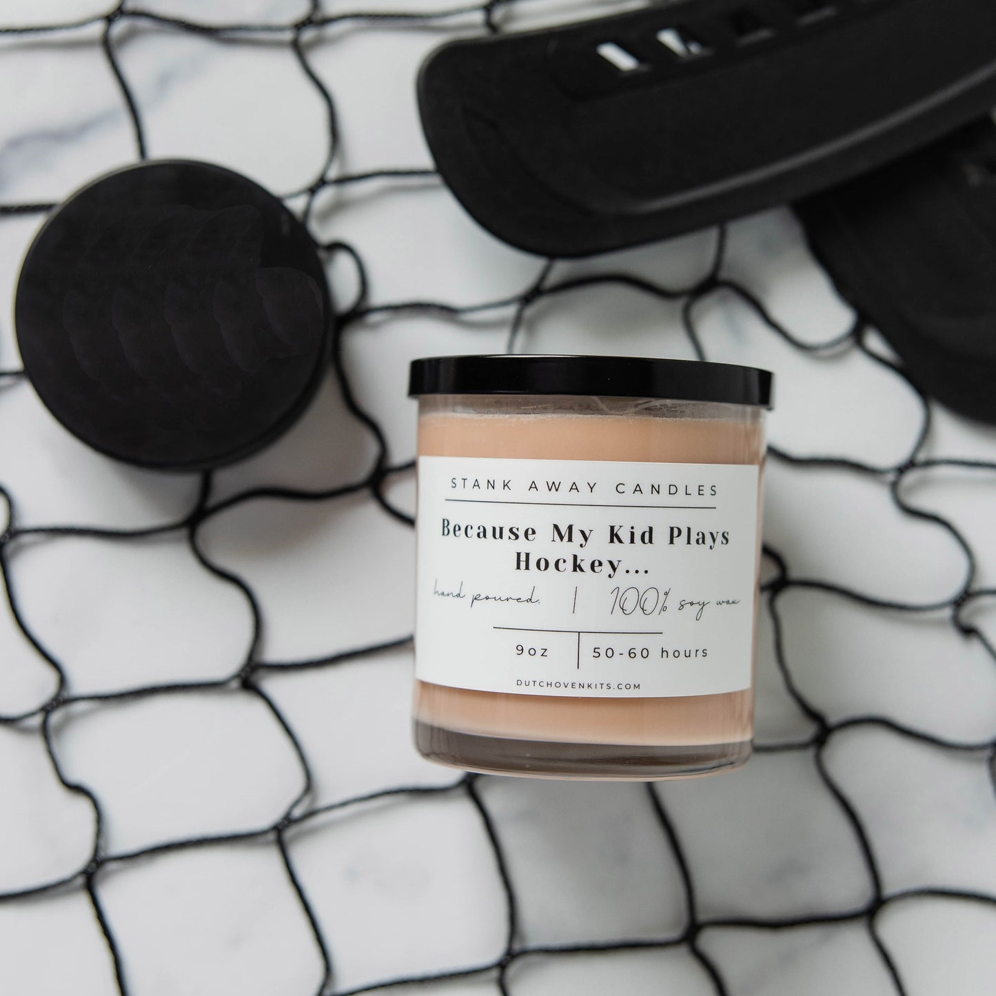 Natural soy wax candle in glass jar with pale beige wax and black lid