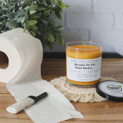 Natural soy wax candle in clear glass jar with orange wax beside white tissue paper