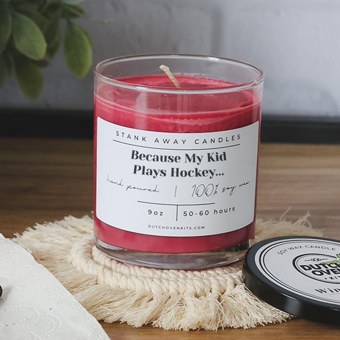 Natural soy wax candle in clear glass jar with red wax; wick centered