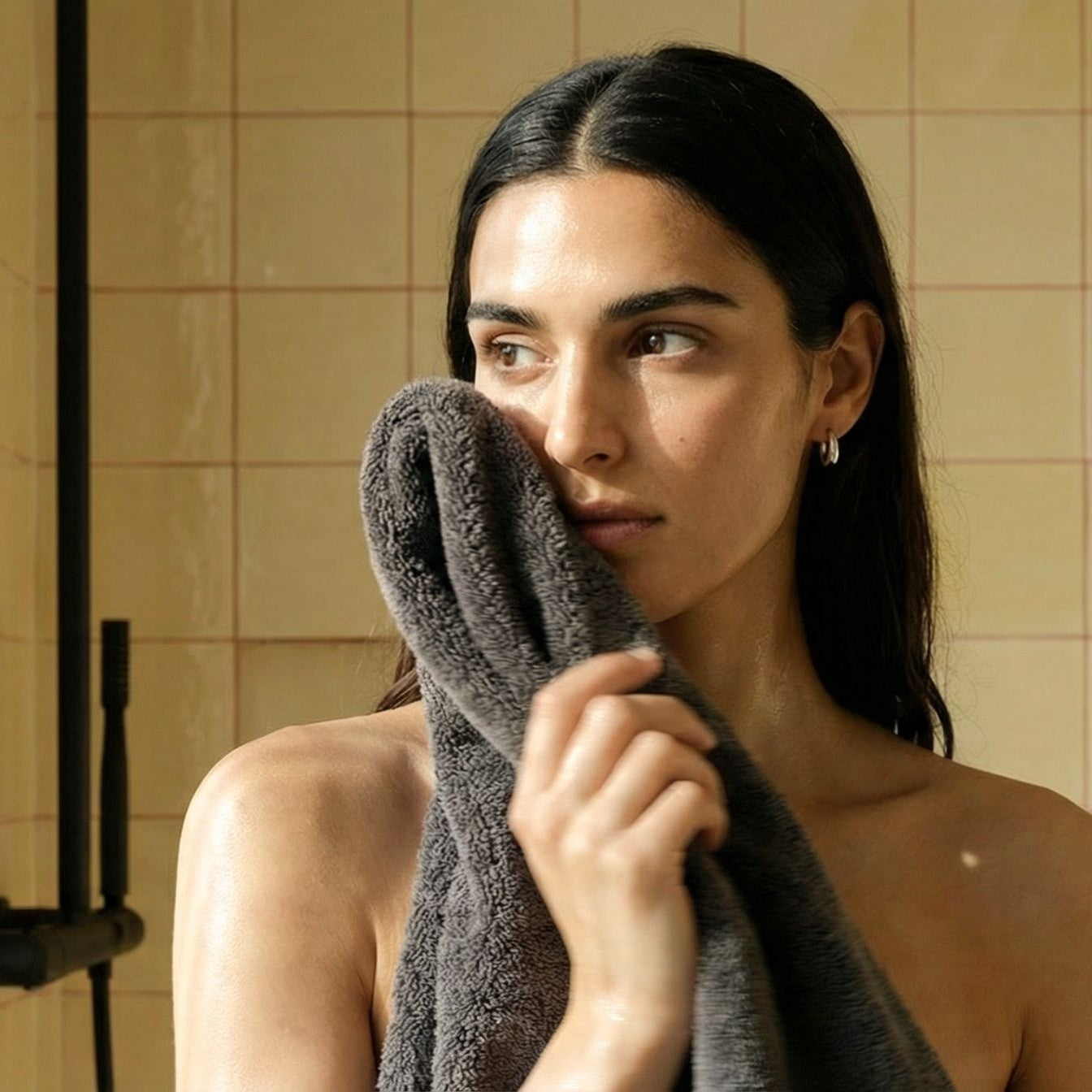 Australian cotton towel in charcoal gray, wrapped around the head and held