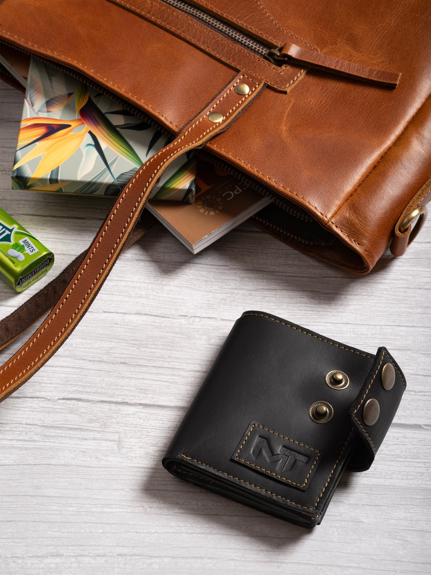 Black leather wallet with metal snap buttons and stitched logo patch