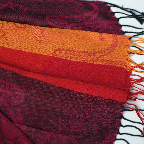 Paisley pashmina scarf detail with burgundy swirls, orange stripe, and white fringes