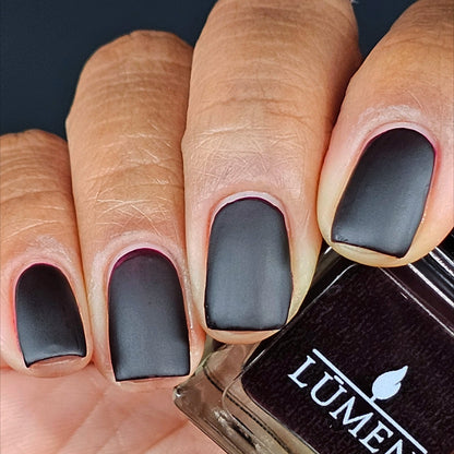 Dark matte fingernails with nail polish bottle showing LUMEN label