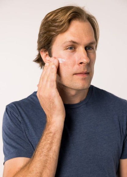 Lightweight mineral SPF 30 sunscreen being applied to face, hand on cheek