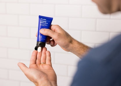 Lightweight mineral SPF 30 sunscreen tube in hand, black nozzle