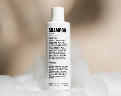 Natural shampoo bottle standing in foamy lather
