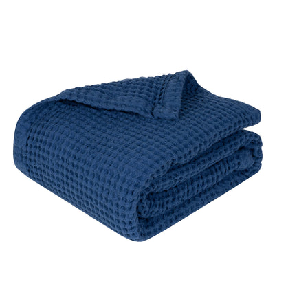 Waffle baby blanket in deep blue, folded stack with raised waffle texture