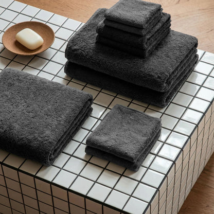 Charcoal gray cotton towels, plush terry, folded stack and separate towels