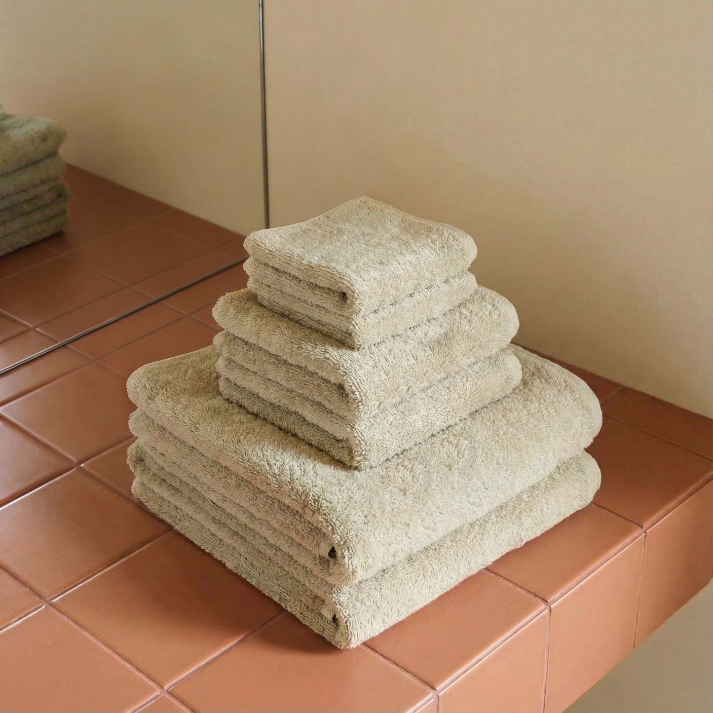 Light beige cotton towels, plush terry, stacked in neat layers