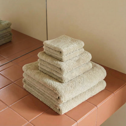 Light beige cotton towels, plush terry, stacked in neat layers